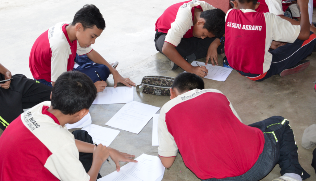 Students are diligently answering the questions in the questionnaire sheets.